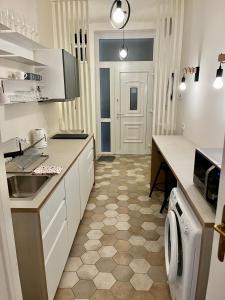a white kitchen with a sink and a dishwasher at A96 in Budapest