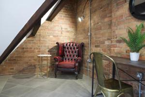 a red chair sitting in a room with a brick wall at Luxury Penthouse In Central Nottingham in Nottingham