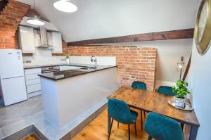 cocina con mesa de madera y sillas azules en Luxury Penthouse In Central Nottingham, en Nottingham