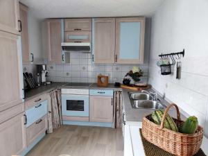 a kitchen with white cabinets and a sink at Ferienhaus Sinneswandel in Sehmatal