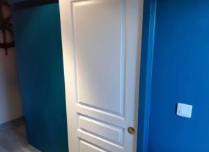 una puerta blanca en una habitación con una pared azul en Studio meublé marne la vallée / Disneyland, en Faremoutiers