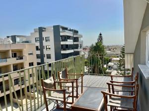 un balcón con sillas y una mesa y un edificio en Trendy Loft Apartment, en Limassol