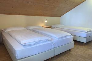 two twin beds in a room with at Appartamenti Ladina in Campitello di Fassa