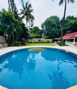 a large blue swimming pool in a yard at Villa by the Sea in Mumbai