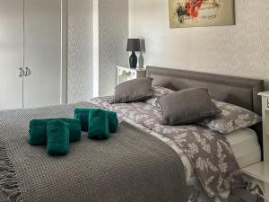 łóżko z zielonymi poduszkami na górze w obiekcie Fiddlers Rest w mieście Ballantrae