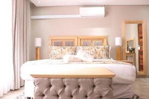 sypialnia z dużym łóżkiem z drewnianym zagłówkiem w obiekcie EDEN BOUTIQUE HOTEL w mieście Kokstad