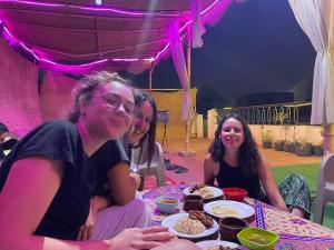 um grupo de mulheres sentadas à mesa com comida em Jana Pyramids view inn no Cairo