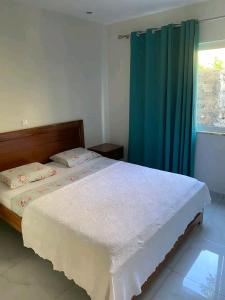 um quarto com uma cama e uma cortina azul em Bentub home em Ribeira Grande