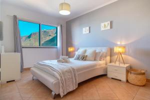 a bedroom with a bed and a large window at Apartment 7 on Paul do Mar Beach in Paul do Mar