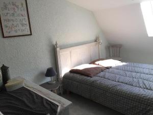 a bedroom with a bed and a table and a lamp at Le Grenier d'annick in Villefort