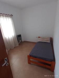 ein kleines Schlafzimmer mit einem Bett und einem Fenster in der Unterkunft DEPARTAMENTO 2 DOR. ZONA PARQUE CON JACUZZI in Paraná