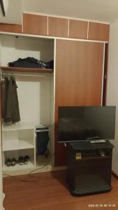 Zimmer mit einem TV und einem Schrank mit einem Regal in der Unterkunft DEPARTAMENTO 2 DOR. ZONA PARQUE CON JACUZZI in Paraná