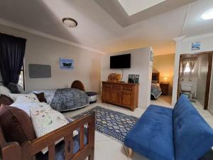 - une chambre avec un lit, un canapé et une télévision dans l'établissement THE POT AIRBNB, FAERIE GLEN, PRETORIA EAST, à Pretoria