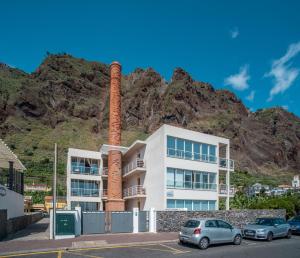 a apartment building with a mountain in the background at Apartment 7 on Paul do Mar Beach in Paul do Mar
