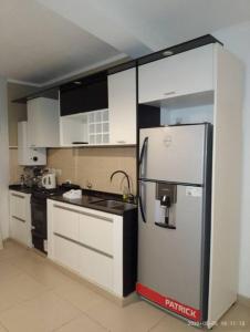 eine Küche mit Kühlschrank und Spüle in der Unterkunft DEPARTAMENTO 2 DOR. ZONA PARQUE CON JACUZZI in Paraná