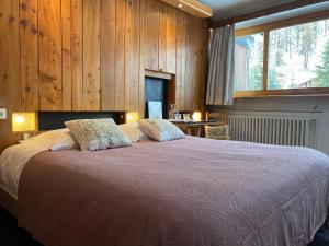 a bedroom with a large bed with wooden walls at Hôtel les Lorès in Val-d'Isère