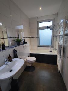 La salle de bains est pourvue d'un lavabo, de toilettes et d'une baignoire. dans l'établissement City Appartement Mönchengladbach, à Mönchengladbach