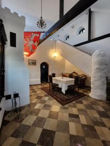 een kamer met een tafel en stoelen en een trap bij Zamek Rycerski in Sobków