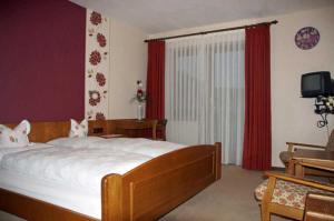 1 dormitorio con 1 cama grande y cortinas rojas en Bayerischer Hof en Amorbach