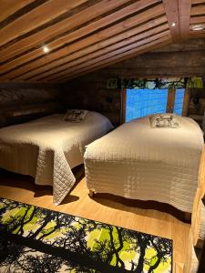 a bedroom with two beds in a log cabin at Casa Levi Luxury Chalet in Levi