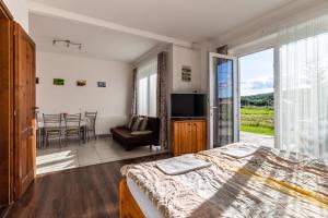 a bedroom with a bed and a sliding glass door at Szabolcs Apartments in Demjén