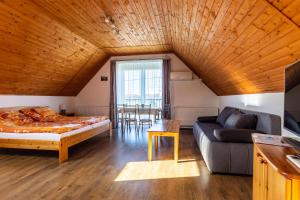 Szabolcs Apartments في ديمجين: غرفة معيشة مع سرير وأريكة