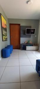 a living room with a door and a tv on a wall at Chaleville Coqueiro 1001 in Luis Correia