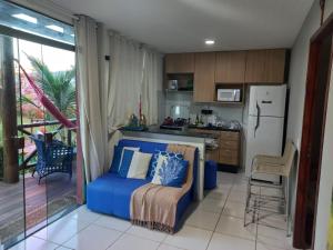 a kitchen with a blue couch and a refrigerator at Chaleville Coqueiro 1001 in Luis Correia