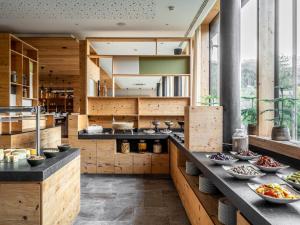 a kitchen with wooden walls and tables with bowls of food at Falkensteiner Hotel Schladming in Schladming