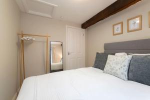 a bedroom with a white bed and a mirror at Cosy & Peaceful Self Contained Home in Montpellier in Cheltenham