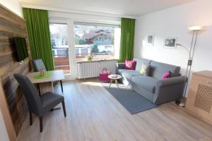 uma sala de estar com um sofá e uma mesa em Appartement „Klein & Fein“ em Bolsterlang