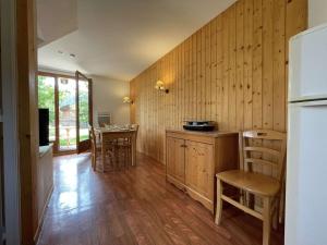 uma cozinha com paredes e pisos em madeira e um frigorífico em Chalet Le Dévoluy, 3 pièces, 4 personnes - FR-1-525-270 em Le Dévoluy