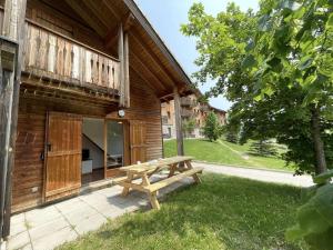 a wooden building with a picnic table in the yard at Chalet Le Dévoluy, 3 pièces, 4 personnes - FR-1-525-270 in Le Dévoluy