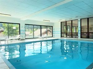 a large swimming pool with blue water in a building at Chalet Le Dévoluy, 3 pièces, 4 personnes - FR-1-525-270 in Le Dévoluy