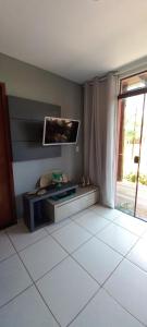 a living room with a tv and a tiled floor at Chaleville Coqueiro 1001 in Luis Correia