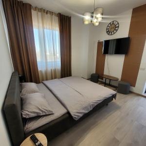a bedroom with a bed and a clock on the wall at Studio Modern Class in Bucharest