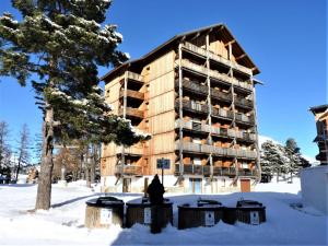 a building in the snow next to a tree at Appartement Le Dévoluy, 2 pièces, 6 personnes - FR-1-525-262 in Le Dévoluy