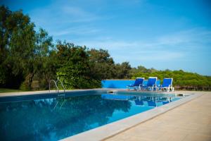 uma piscina com espreguiçadeiras azuis ao lado em Monte Alerta Turismo Rural em Monsaraz