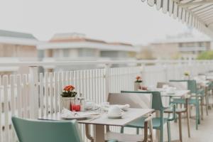 Hotel Bellavista في غرادو: صف من الطاولات والكراسي على الشرفة