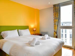 a bedroom with a large bed with white towels on it at Pass the Keys A place in the city with parking in Cardiff