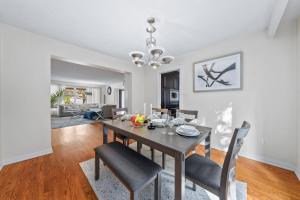 a dining room and living room with a table and chairs at Bright and spacious house close to subway in Toronto