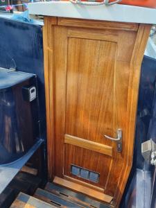 een houten deur aan de zijkant van een boot bij The Royal Escape Windsor, Static Wide Beam Barge in Eton