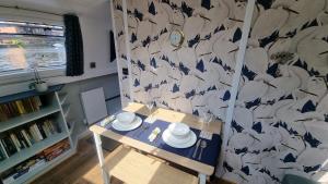 une chambre avec une table et un mur avec des oiseaux dans l'établissement The Royal Escape Windsor, Static Wide Beam Barge, à Eton