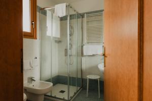 a bathroom with a glass shower and a sink at Hotel Bellavista in Grado