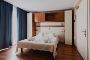 Hotel Bellavista في غرادو: غرفة نوم عليها سرير وفوط