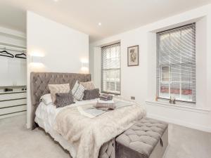 a white bedroom with a large bed and windows at Spire View in Aberdeen