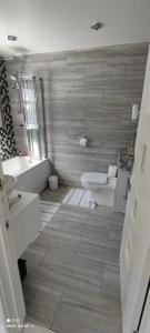a bathroom with a tub and a toilet and a sink at West Dulwich Home 28 Mins to London Victoria in London