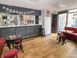 a bar with a couch and a table and chairs at The Grey Bull Apartment in Hexham