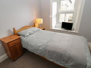 a bedroom with a bed and a window and a television at The Grey Bull Apartment in Hexham