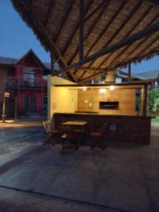 a patio with a table and chairs under a roof at Chaleville Coqueiro 1001 in Luis Correia